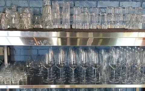 Selective focus. pile of empty transparent glasses on shelf. Close up of Stock Photos