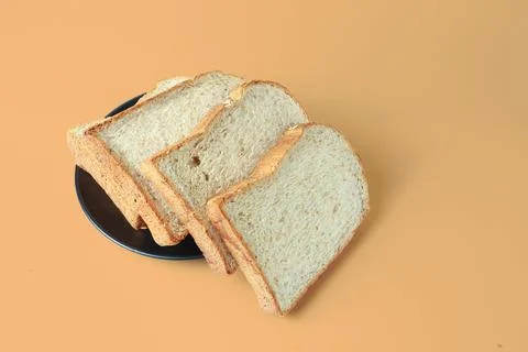 Selective focus of pile of toasted bread slices on a single black plate. On p Stock Photos