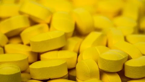 Selective focus on pile of yellow tablets pills . Ibuprofen tablets pills. Pa Stock-Fotos