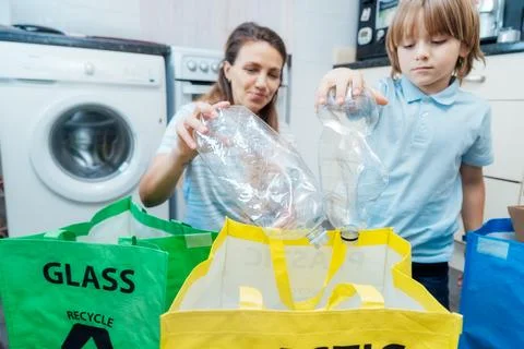Selective focus on plastic bottles, concept of recycling. Mother educates son on Stock Photos