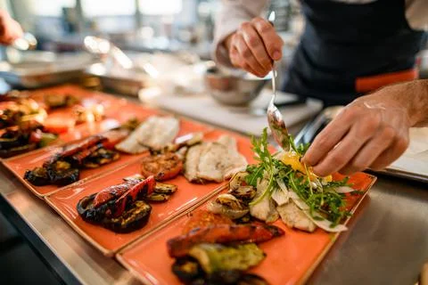 Selective focus on plate with dish which man cook decorates with sauce 스톡 사진