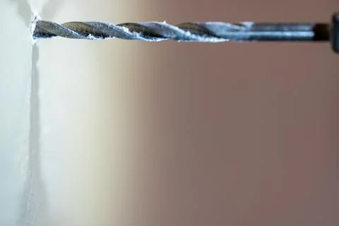 Selective focus on point of penetration of a drill bit making a pilot hole in Stock Photos