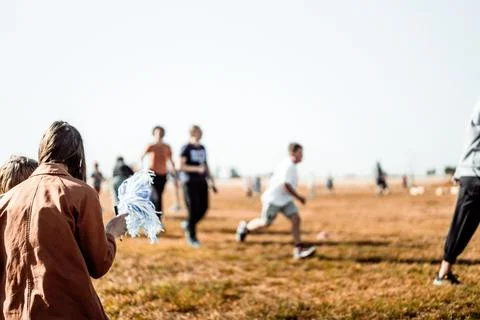 Selective focus on a pom-pom streamer with defocused child running in the Foto stock