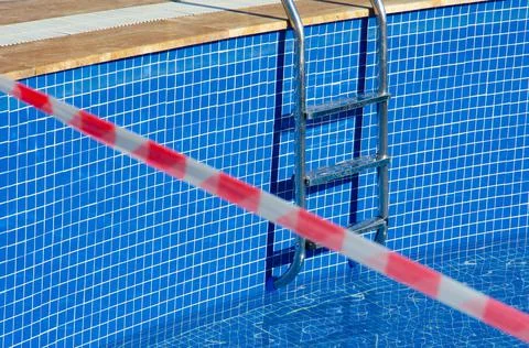 Selective focus on pool with no-entry tape. Red and white tape. Stock Photos