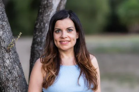 Selective focus portrait of a smiling middle-aged latina woman in a park Stock Photos