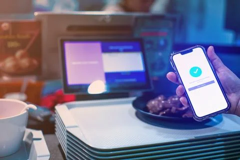 Selective focus to POS smart device with blurry custom hand holding smartph.. Stock Photos