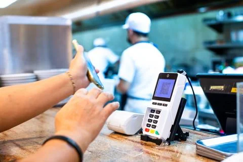 Selective focus to POS smart device with blurry custom hand holding smartph.. Stock Photos