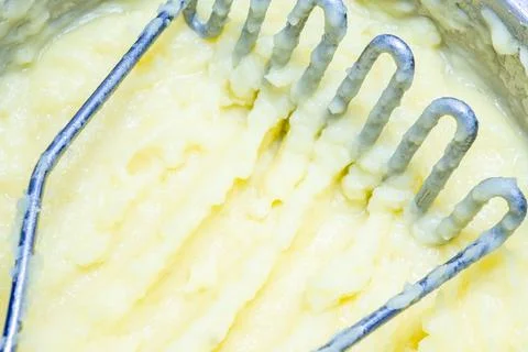 Selective focus on potato masher in fresh mashed potatoes. Stock Photos