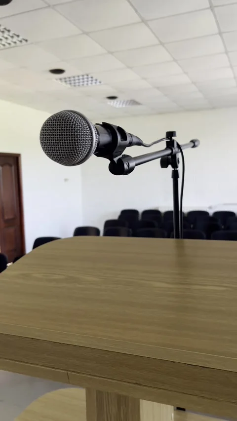 Selective focus on preparation for speech with microphone in quiet venue Stock Footage 313714123