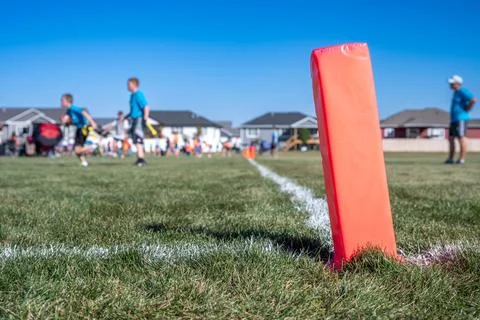 Selective focus on a pylon with a defocused flag football game in the background Stock Photos
