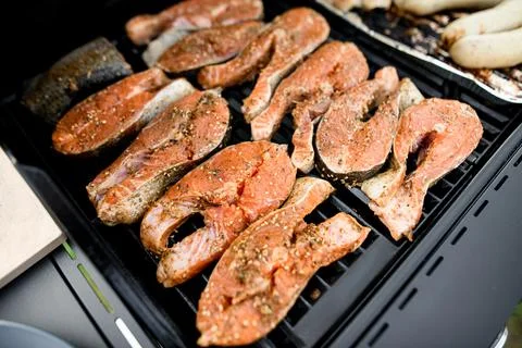 Selective focus on raw salmon steaks on grill 스톡 사진