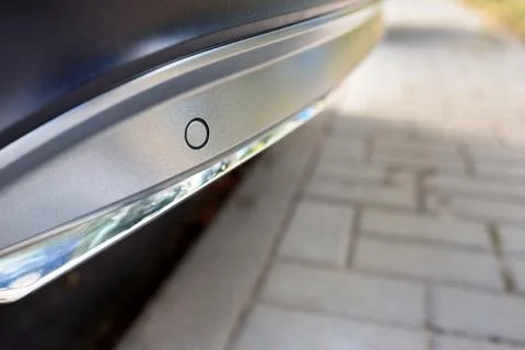 Selective focus on rear bumper left side parking sensor at back of luxurious car Stock Photos