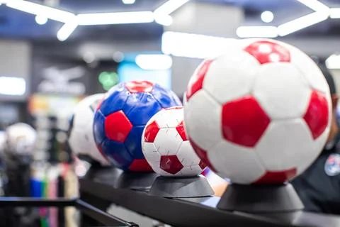 Selective focus to red and white soccer ball displayed on a shelf in a mode.. Stock Photos