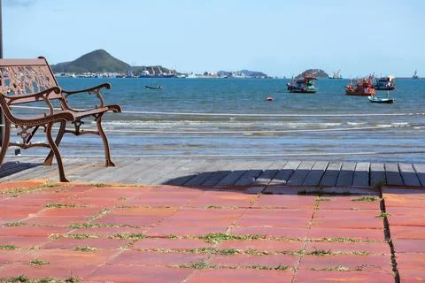 Selective focus on a red bench next to the sea.  Stock Photos