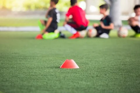 Selective focus to red cone marker is soccer training equipment on green arti Stock Photos