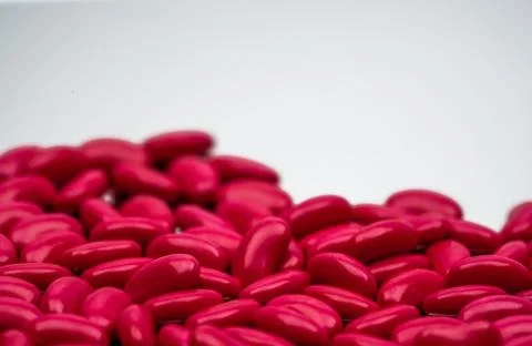 Selective focus of red kidney shape sugar coated tablet pills on white backgr Stock Photos