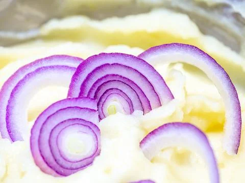 Selective focus on red onion slices in mashed potatoes. Stock Photos