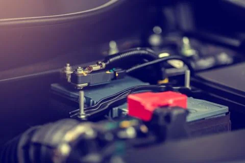 Selective focus to red positive pole of battery in yellow car. Stock Photos