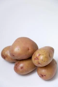 Selective focus of red potato on white background Stock Photos