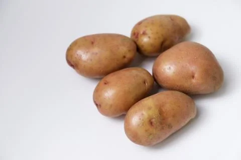 Selective focus of red potato on white background Stock Photos