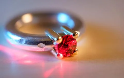 Selective focus of red ruby diamond ring Isolated on wooden background Foto stock
