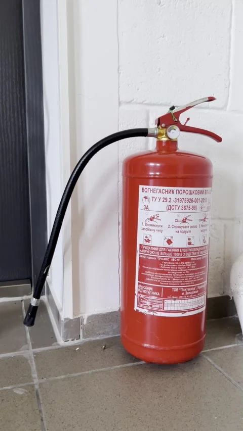 Selective focus on safety equipment fire extinguisher in office interior Stock Footage 313713829