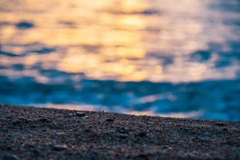Selective focus on the sand on the beach during sunset at sea. Stock Photos