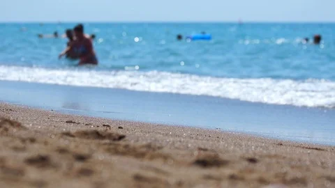 Selective focus. Sandy beach, defocused people. Video stock 100878429