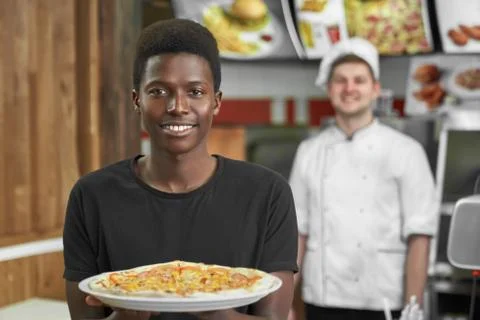 Selective focus of satisfied client keeping delicious pizza Stock Photos