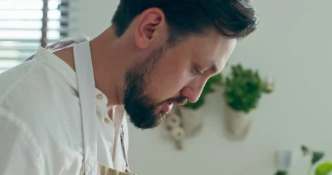 Selective focus on serious concentrated bearded man in apron cooking baking Stock Footage 218963934