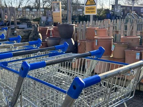 Selective focus on shopping trolley handle, plant pots stacked in the backgor Foto stock