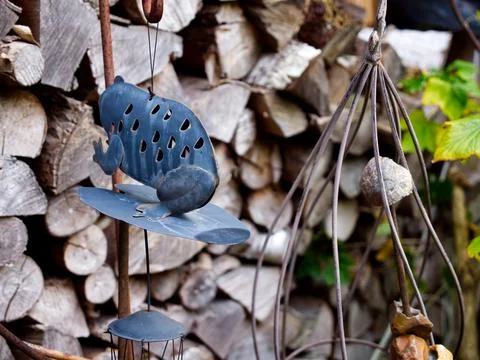 Selective focus shot of decorative wind chimes in front of a firewood stack Stock-Fotos