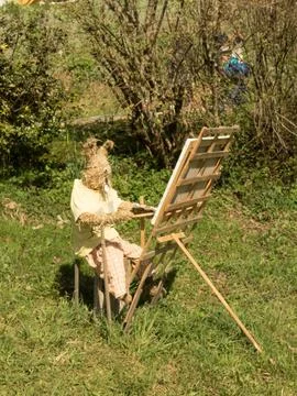 Selective focus shot of a funny Easter bunny made from straw drawing a pictur Foto stock