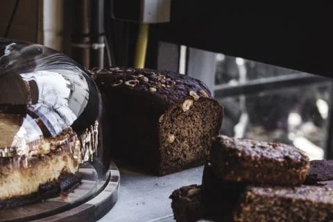 Selective focus shot of a grain bread near desserts with a blurred background Stock Photos