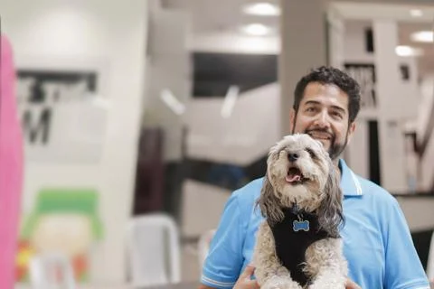 Selective focus shot of a Hispanic man holding a cavapoo puppy Fotos de archivo