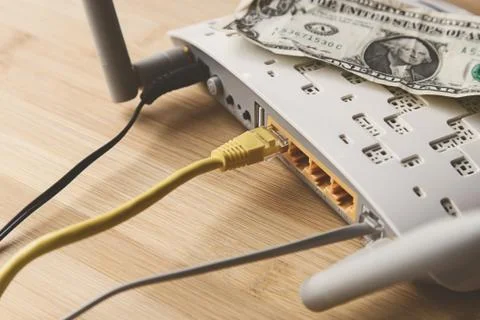 Selective focus shot of an internet modem with a dollar bill on top of it 写真素材