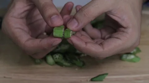 Selective focus shot of man's hand cutting okra Stock Footage 139260075
