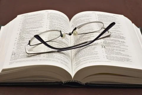 Selective focus shot of optical glasses on an open book Stock Photos