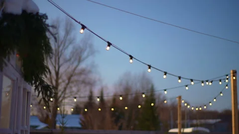 Selective focus shot of outdoor string lights hanging on line on outside house Stock Footage 262746878