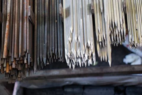 A selective focus shot of sharp headed metallic objects hanging with a dark b 库存照片