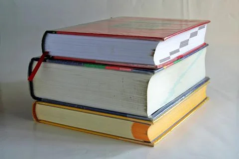 Selective focus shot of a stack of three old books on a white surface Stock Photos