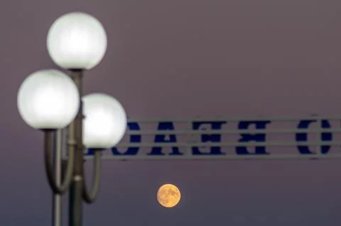 Selective focus shot of the yellow moon in a dark purple sky Foto stock