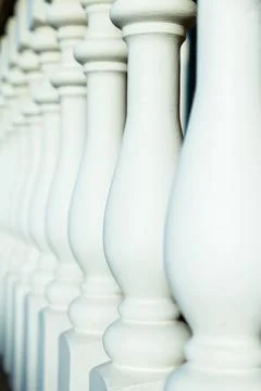 Selective focus side view of white painted newel posts in old porch railing Stock Photos