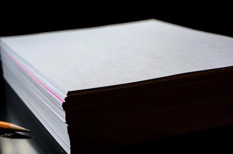 Selective focus on a single colored sheet in a stack of plain white paper Stock Photos