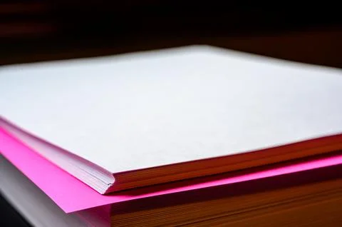 Selective focus on a single colored sheet in a stack of plain white paper Foto stock