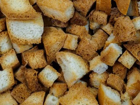 Selective focus on slices of fried white bread close-up. Tasty rosy croutons. Stock Photos