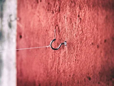 In selective focus of small hook with rope on grunge surface cement wall,abst Foto stock