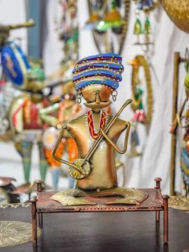 Selective focus on the small metal statue of a traditional man from sitting o Stock Photos