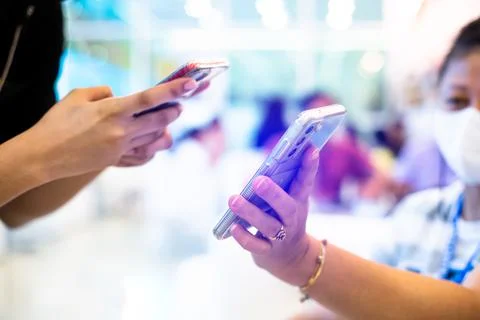 Selective focus to smartphone in the hands of customer and merchant to scan a Stock Photos