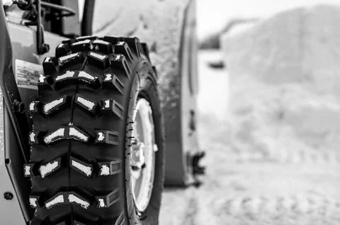 Selective focus on snowblower tires with a defocused drift of snow in background Stock Photos
